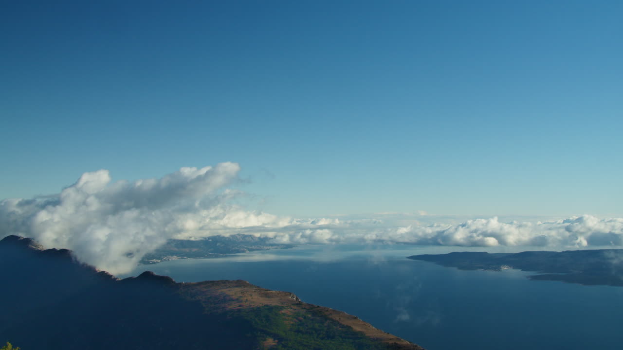 겨울철 바다 옆 크로아티아 산의 정상 하늘 타임랩스