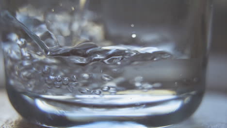 water bubbles while pouring in glass up close in slow motion