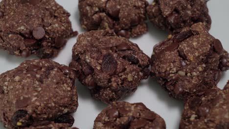 Galletas-De-Avena-Con-Pasas-De-Chocolate-Giratorias-Sobre-Fondo-Blanco,-Detalle-De-Primer-Plano