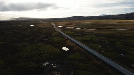 por un largo camino en la sombra en un día soleado en islandia