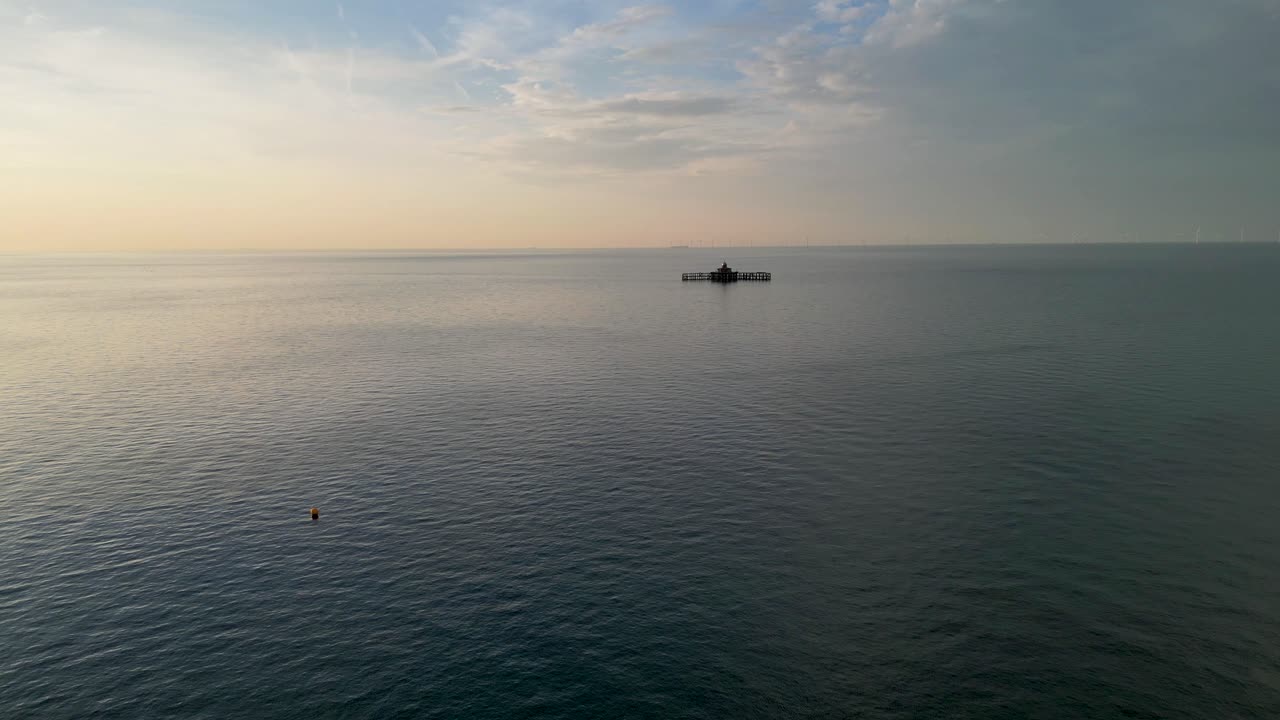 Calm sea with a ruined pier on the horizon