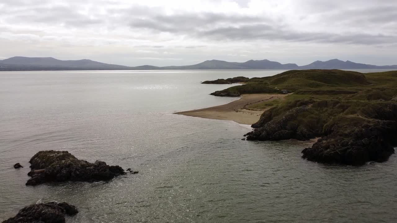 아일랜드 해를 가로지르는 스노도니아 산맥이 있는 이니스 란드윈 섬 앵글시 해안 산책로 위로 공중으로 떠오르는 전망