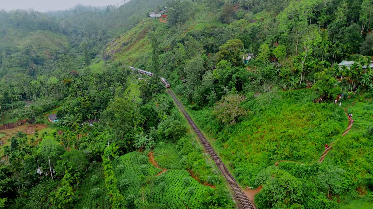 Mozzafiato riprese aeree con drone di un treno che attraversa l'iconico Ponte dei Nove Archi a Ella, Sri Lanka.