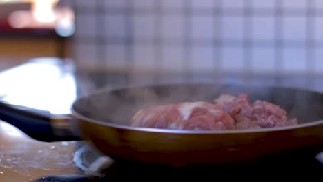 el hombre está ocupado cocinando tocino en una sartén