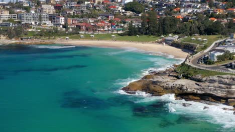 playa de bronte con olas rompiendo contra los acantilados rocosos de bronte marine drive en nsw, australia
