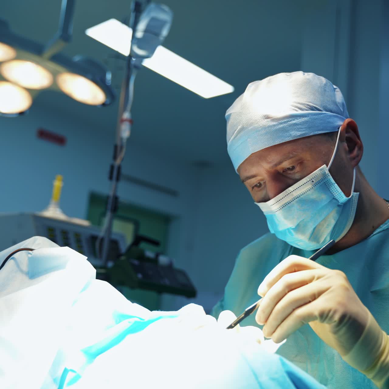 Surgeon doing plastic surgery. Professional doctor in medical mask does blepharoplasty in modern clinic. Male specialist uses medical tools during operation.