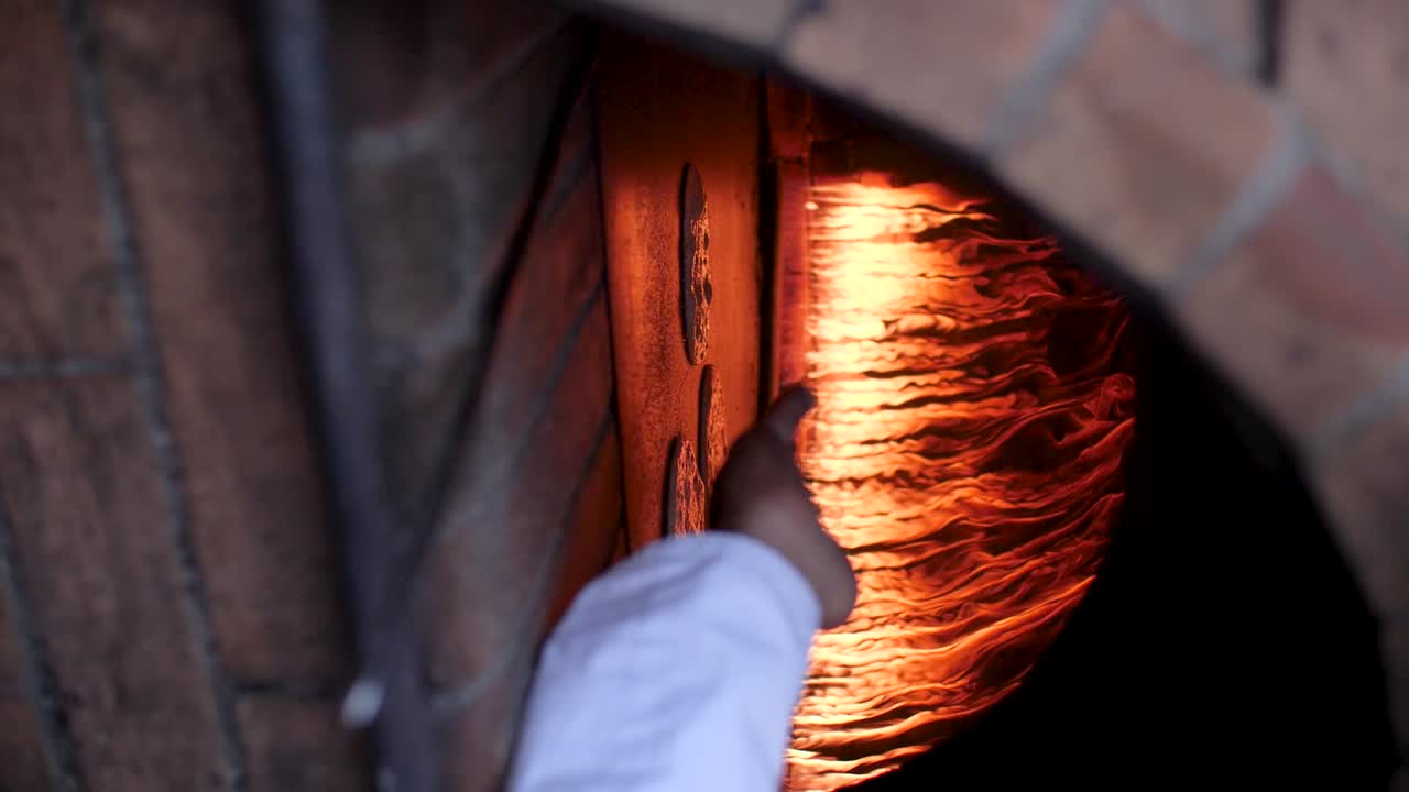 Mettere il pane arabo tradizionale a cuocere all'interno di un forno a legna