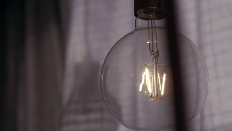 glowing indoor home decor lamp hanging in living room, dynamic motion shot