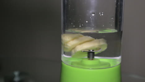 slices of banana with liquid put in the blender ready for making fruit shake - close up shot