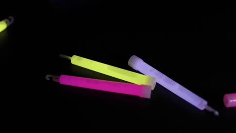 glow sticks falling and landing on a dark surface