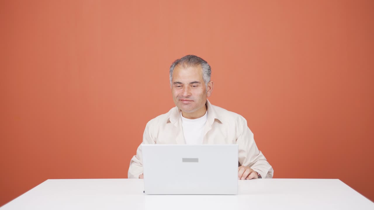 행복한 표정으로 노트북에서 일하는 남자.