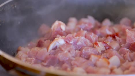 bacon ocupado fritando en una sartén y también se agita