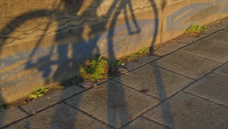 sombra en cámara lenta de ciclista en bicicleta para ir al trabajo durante la puesta del sol