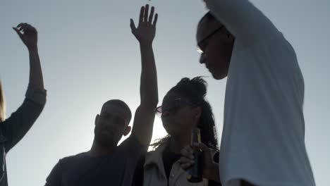 Smiling-young-people-dancing-with-raised-hands.