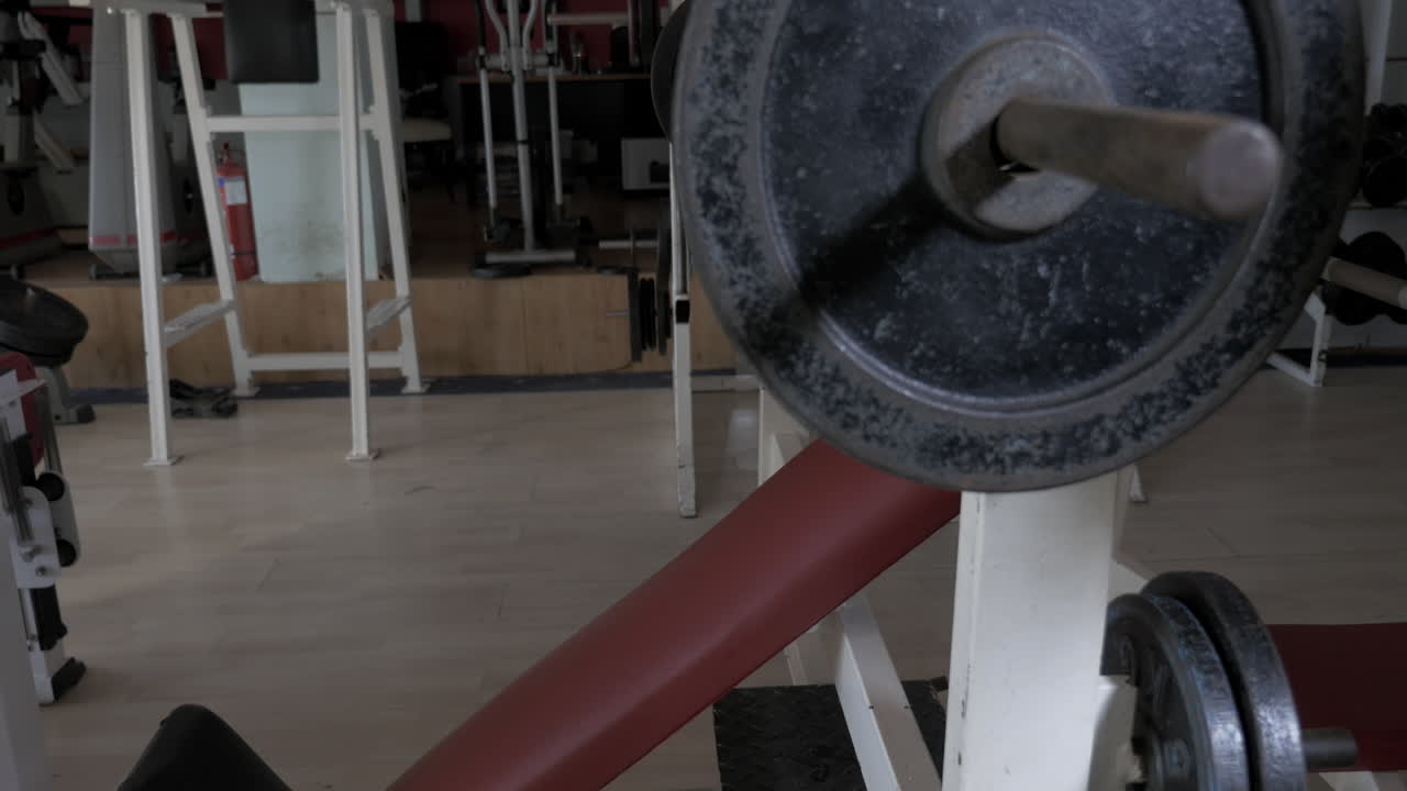 Young man at the gym doing exercise chest press with rod