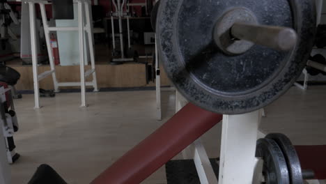 Young-man-at-the-gym-doing-exercise-chest-press-with-rod