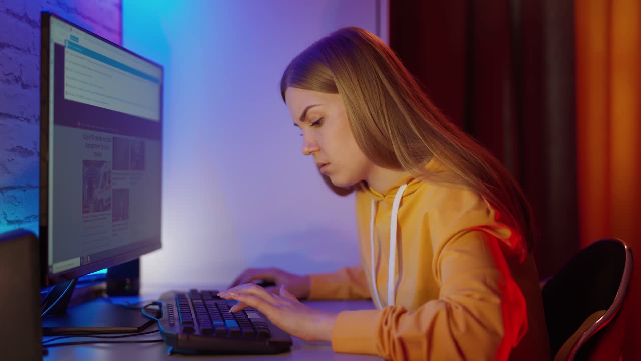 Woman using computer at home. Woman sitting at the table at home, working on computer