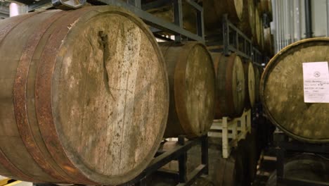 plano medio ancho inclinado hacia abajo de barriles de bourbon fermentando dentro de una destilería