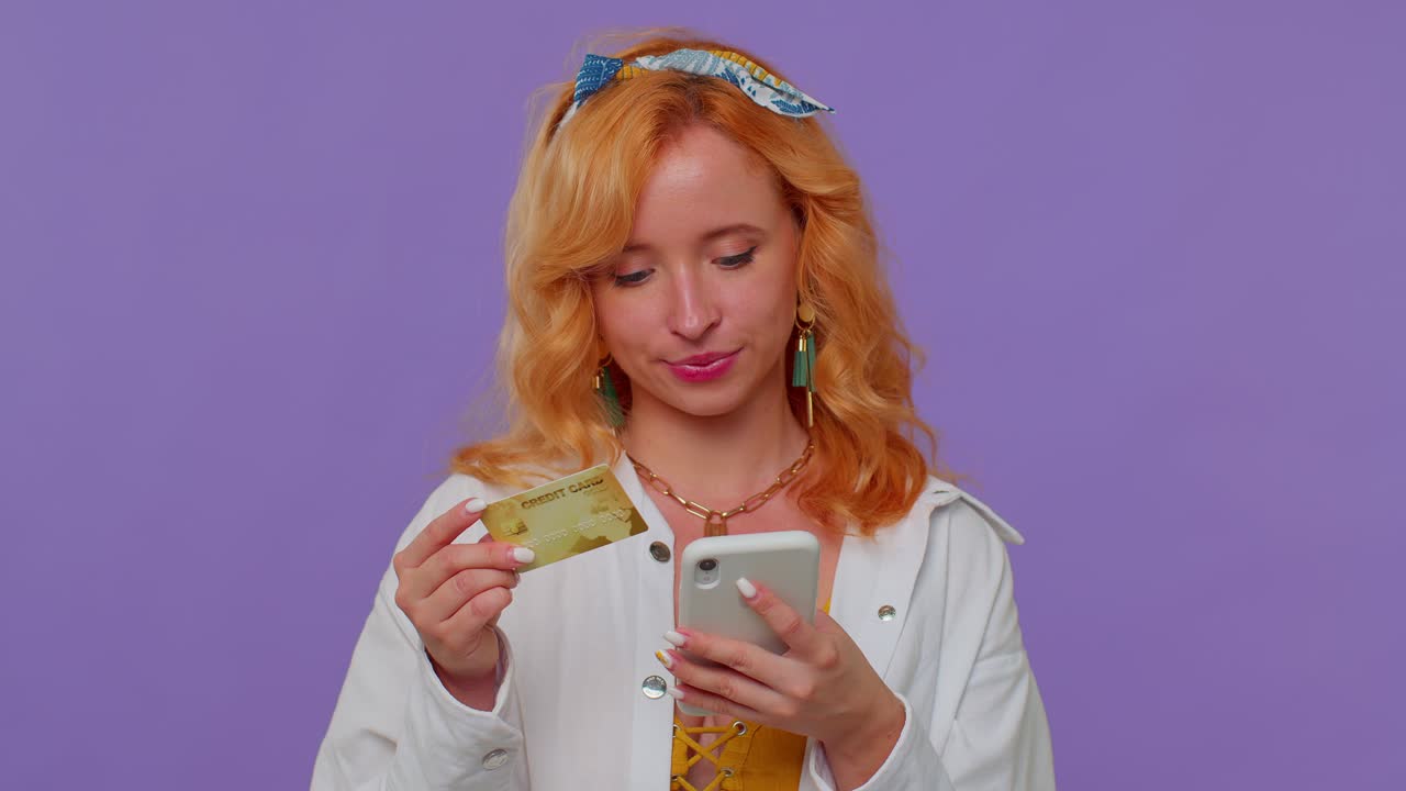 donna che utilizza una carta di credito e uno smartphone per trasferire denaro, fare acquisti online