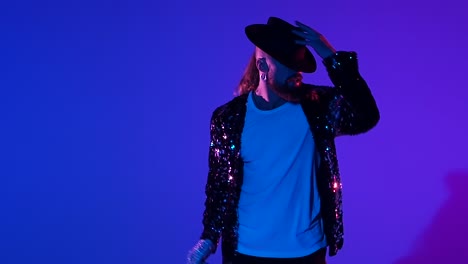 man in sequin jacket and fedora dancing in studio