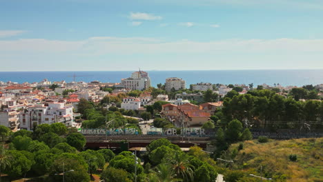 Drone-footage-captures-coastal-homes-by-beach,-offering-breathtaking-views-of-vast-sea-on-a-sunny-day