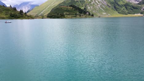 tilt up, view of an alpine lake with clear water in obwalden, drone aerial view, mountains and tree in the background