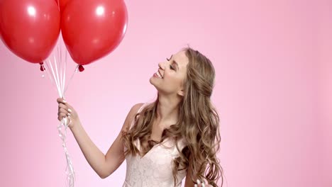 Happy-woman-with-red-balloons-blowing-a-kiss