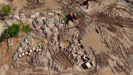 aerial view of construction site with excavator and pipes