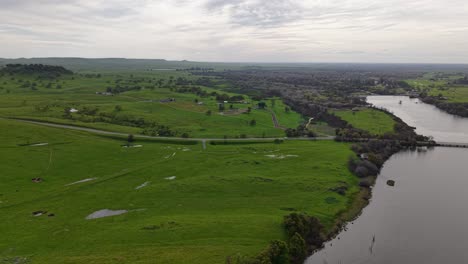 rotating aerial view of lake mcswain dam and the surroundings of merced california in the distance.