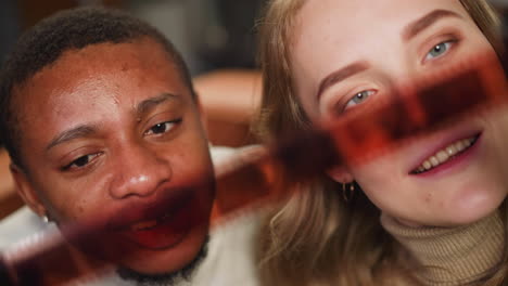 hombre afroamericano con mujer blanca mira una película de color