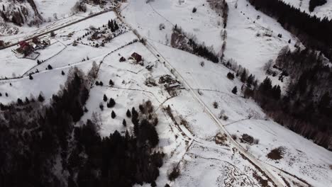 Toma-Aérea-Sobre-Un-Pequeño-Pueblo-En-La-Montaña-En-Invierno