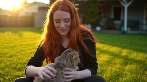 a joyful moment: a young woman enjoying quality time with her playful cat in a sunlit garden, embracing the warmth of friendship and nature.