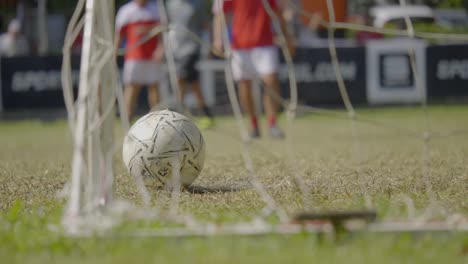 slow motion shot of goal keeper shooting ball in soccer game on green field