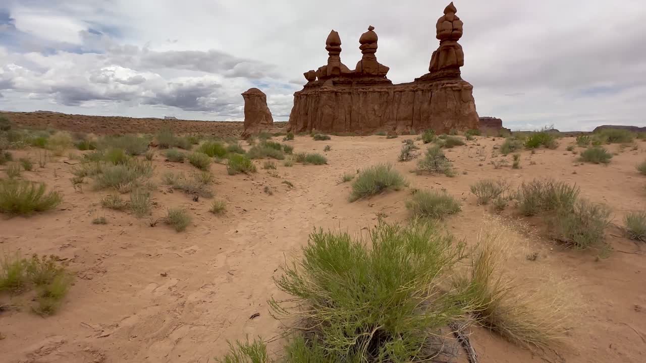 Tilt up to reveal the Three Sisters rock formation in Utah's goblin valley