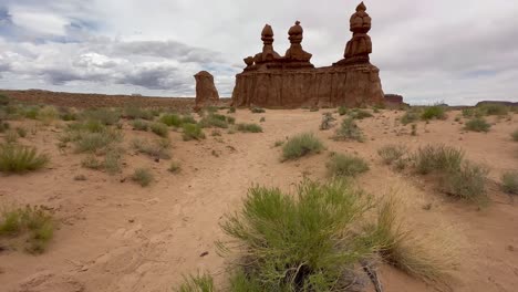 Tilt up to reveal the Three Sisters rock formation in Utah&#039;s goblin valley