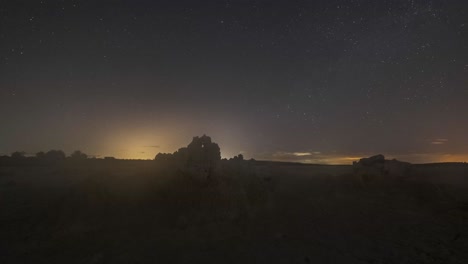 cielo estrellado con la vía láctea sobre el terreno desértico