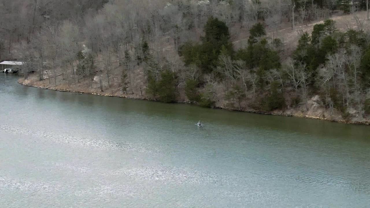 fishing in a kayak by lake shoreline