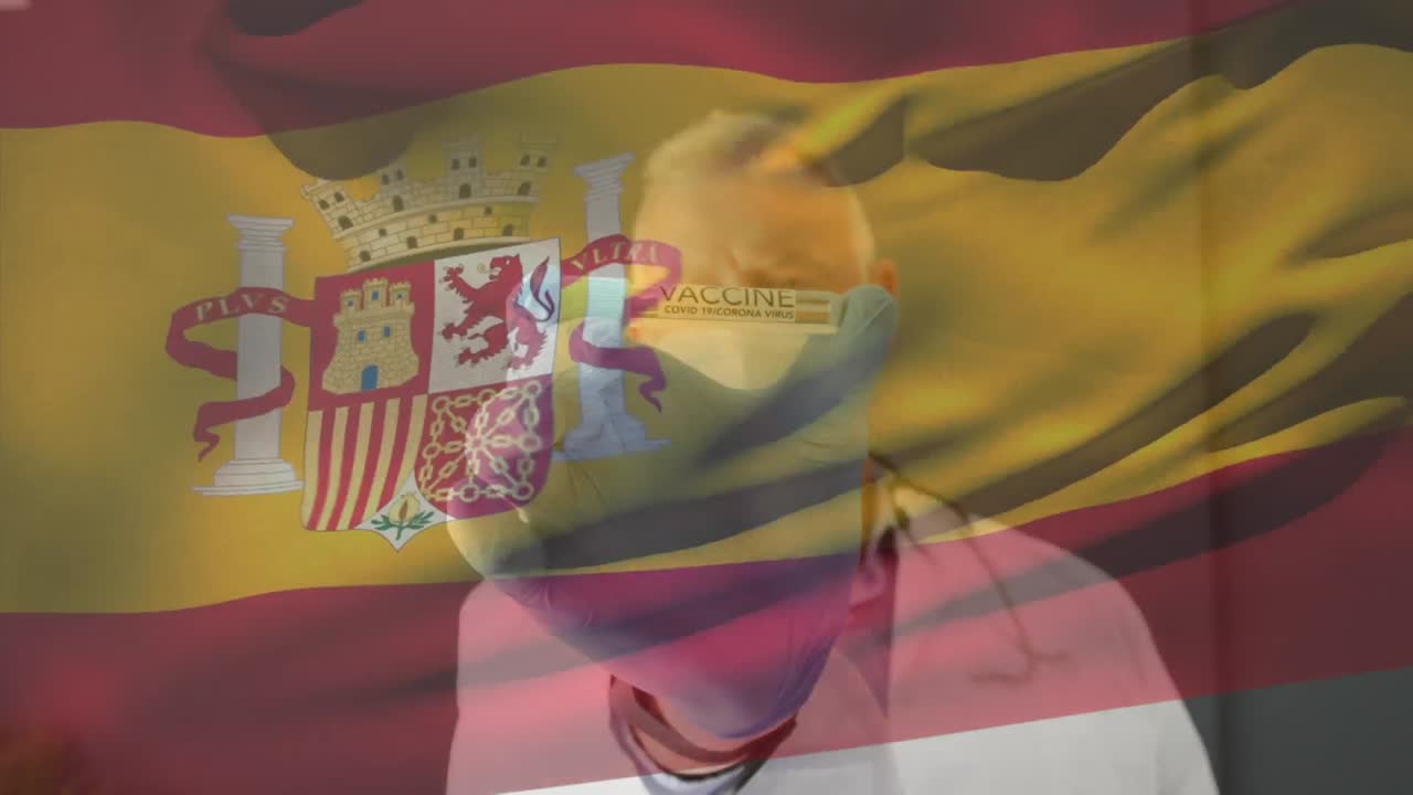 animación de la bandera de españa ondeando sobre el médico con máscara facial y con la vacuna en la mano