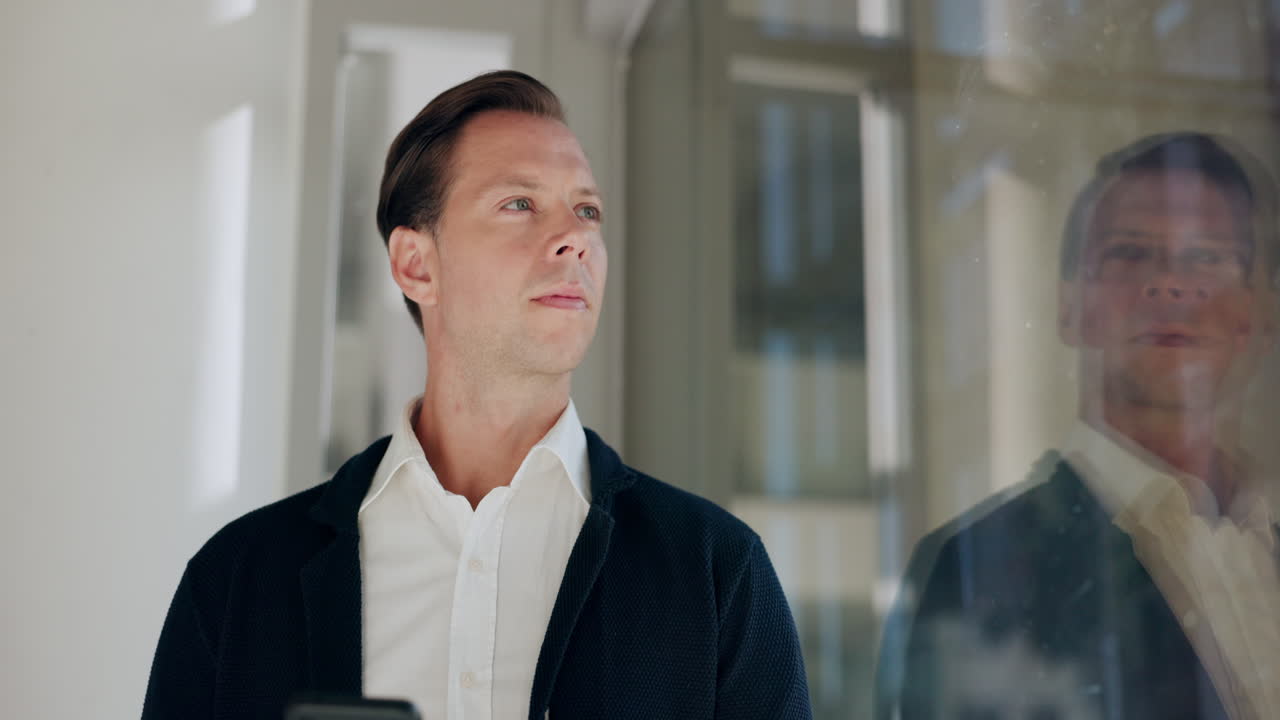 사무실 복도에서 스마트폰으로 문자 메시지를 보내는 사업가