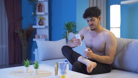 young man applying treatment cream to his pain.