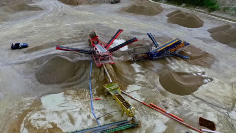 huge open pit sand and gravel mining quarry - tilt down aerial reveal