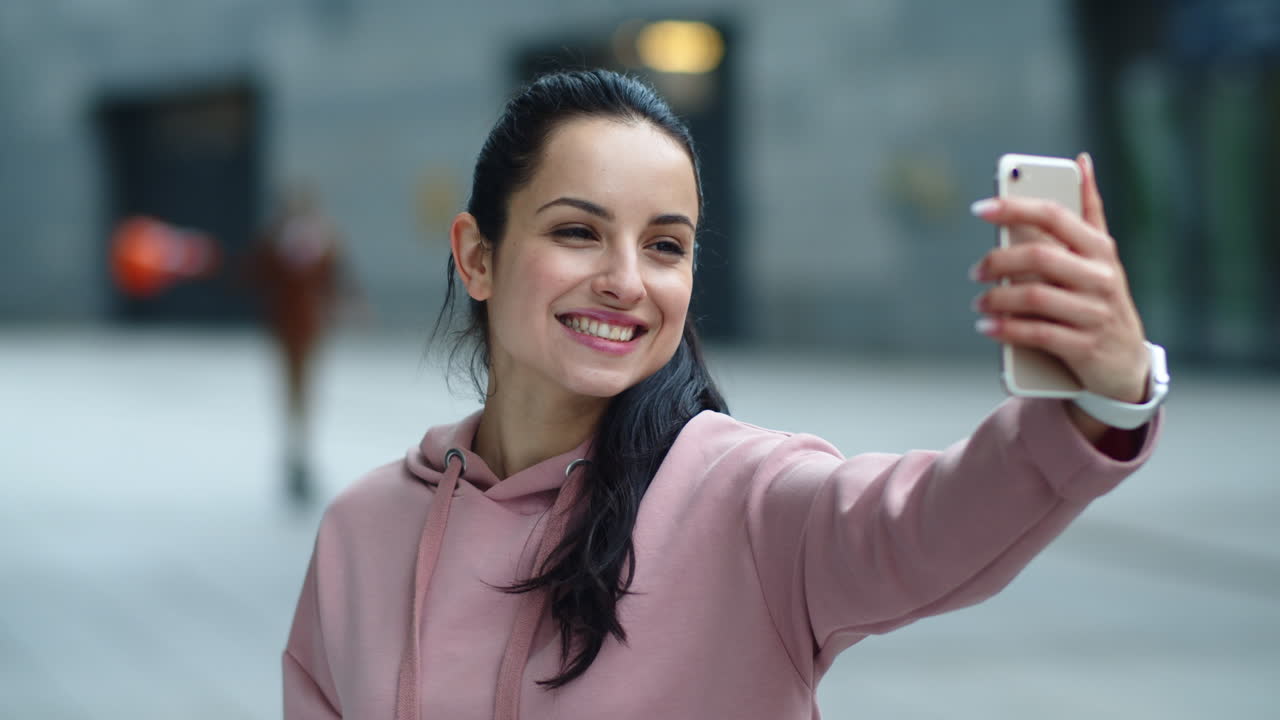 Primo piano di donna sorridente che usa il telefono per una videochiamata. Ragazza allegra che parla online.