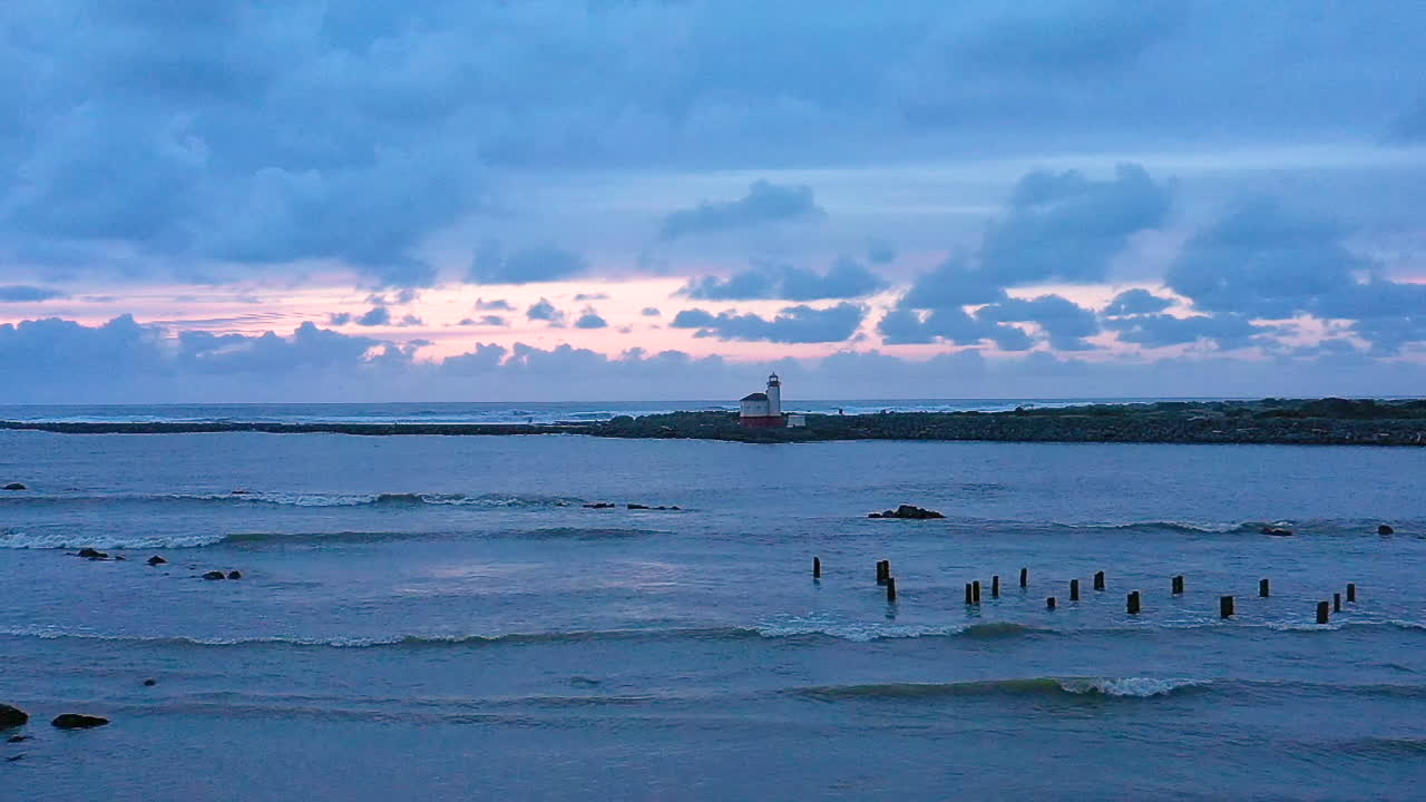 드론이 강 위로 천천히 하강하는 슬로우 모션 비디오, 배경에 있는 코퀼 강 등대