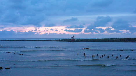 Zeitlupenvideo-Einer-Drohne,-Die-Sich-Langsam-über-Den-Fluss-Senkt,-Im-Hintergrund-Der-Leuchtturm-Des-Coquille-River