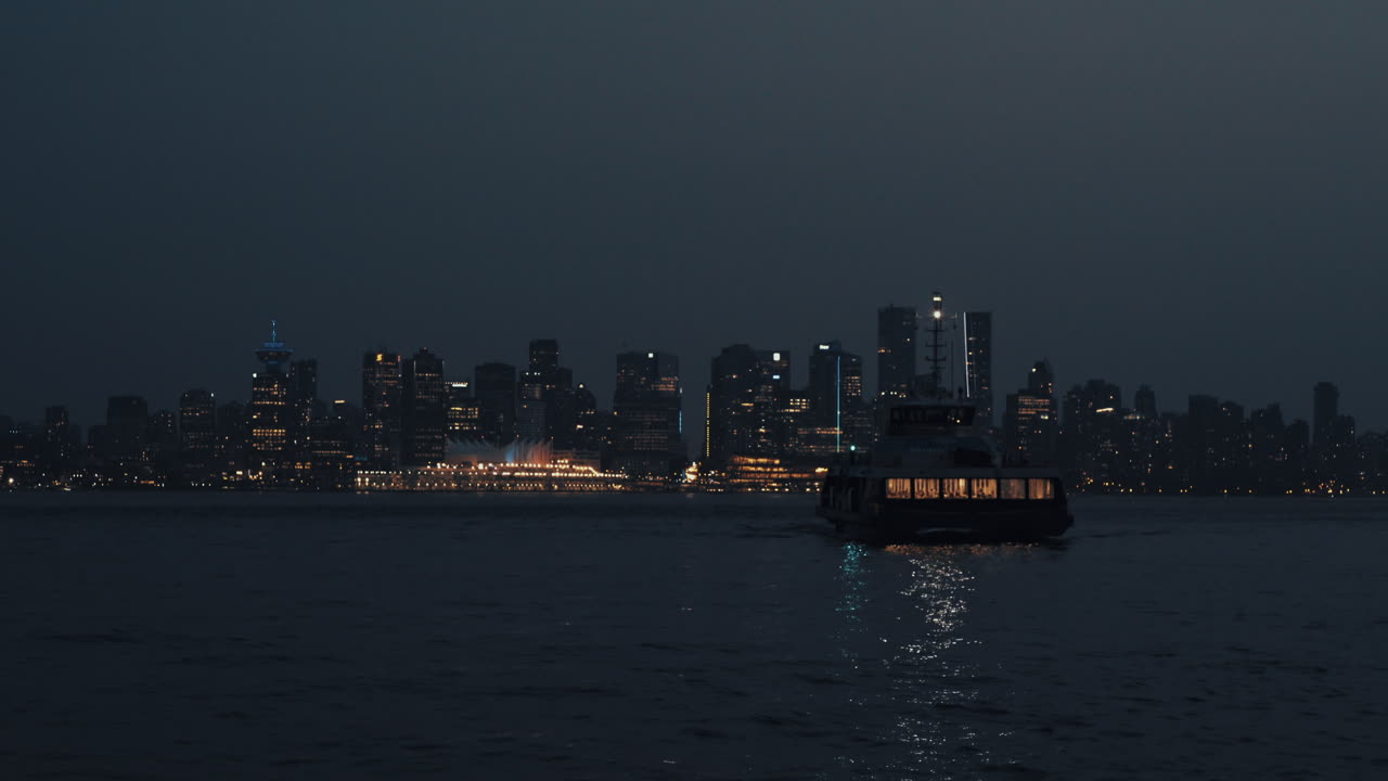 морской автобус прибывает на северный берег ночью с горизонтом ванкувера на заднем плане