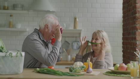 Happy Elderly Couple Having Fun with Vegetables in the Kitchen