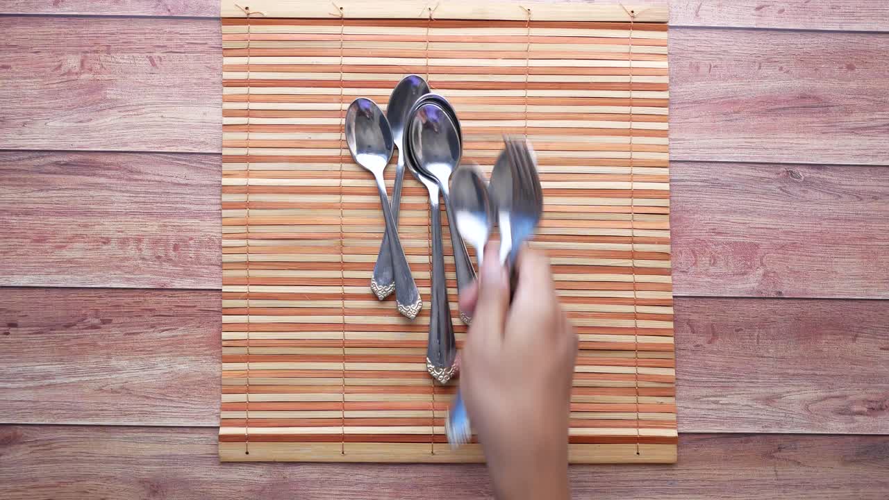 pila de cucharas y tenedores en un cojín de bambú