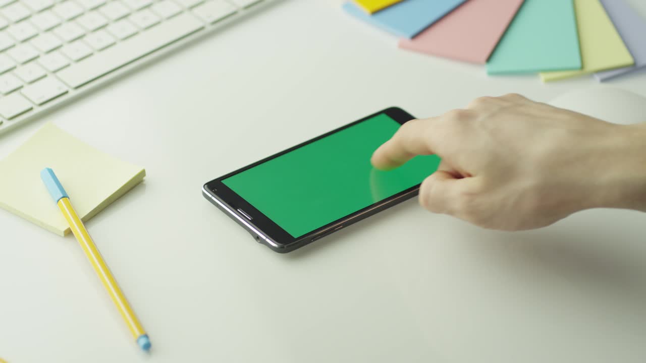 디자이너는 안드로이드 드폰을 사용하여 녹색 화면을 풍경 모드로 설정합니다.