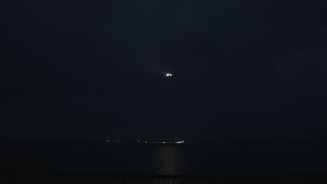 night airplane landing over the ocean