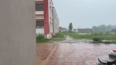 tracking shot of heavy rain, water coming out from the drain pipe of the building
